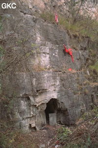 Petite grotte avec pierre tombale ? et tissus rouge probablement signe religieux bouddhiste. Nous sommes en rive droite sur le petit sentier qui descend dans les gorges de la Chaibuxi. (Changpuxi, Wufeng, Hubei)