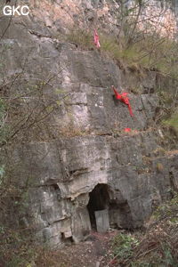 Petite grotte avec pierre tombale ? et tissus rouge probablement signe religieux bouddhiste. Nous sommes en rive droite sur le petit sentier qui descend dans les gorges de la Chaibuxi. (Changpuxi, Wufeng, Hubei)